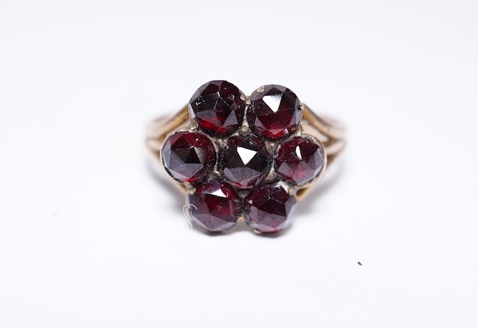 A suite of garnet and paste jewellery, comprising: a brooch, 5cm diameter; a bangle, inner circumference 16cm; two rings, sizes I and M; a pair of earrings, and a single earring, each set with rose-cut garnets; and a pai